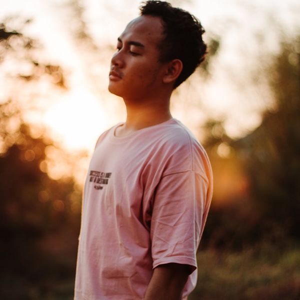 Person meditating in a serene environment with soft, golden light.
